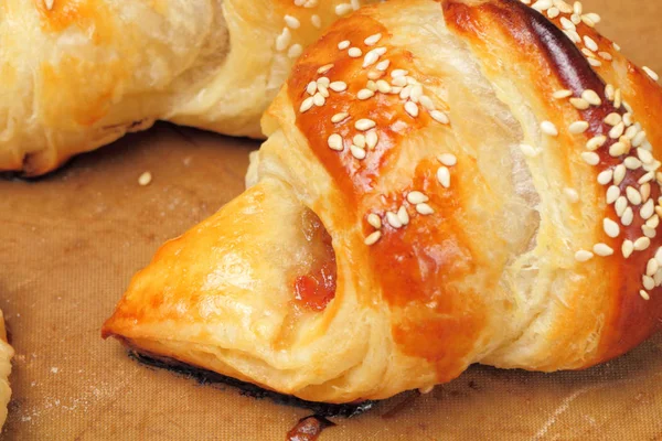 Homemade croissants with apricot jam and sesame seeds are fresh from the oven