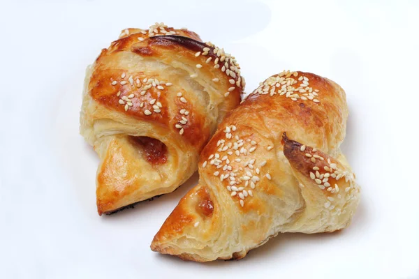 Homemade croissants with apricot jam and sesame seeds are fresh from the oven