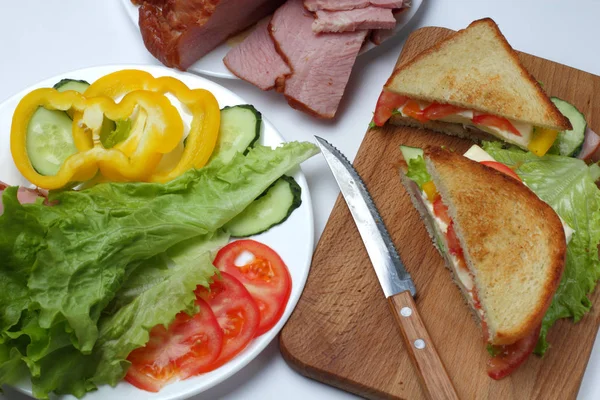 Sandwich Med Skinka Sallad Skivor Ost Tomater Skär Bräda Vit — Stockfoto