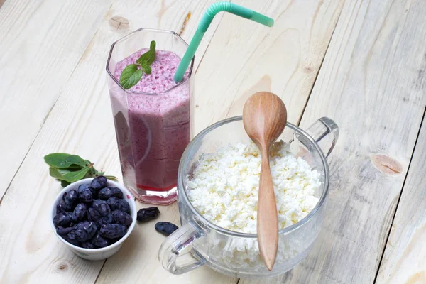 Bir kokteyl ile taze süzme peynir Rustik kahvaltı, vitamin ferahlatıcı hanımeli çilek, küçük bir kase içinde hanımeli. Yakın çekim, metin alanı, doğal ahşap arka plan.