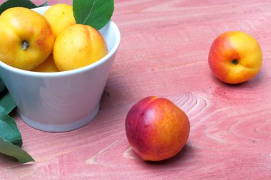 Olgun nektarinler veya kayısı masada ahşap bir sprig ile, yakın çekim, doğal renkler.