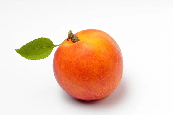Rijpe Nectarine Abrikoos Met Een Groen Blad Een Witte Achtergrond — Stockfoto