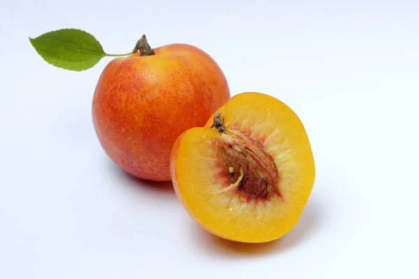成熟的花蜜或杏与绿叶和切水果与骨头在白色背景 自然的颜色 — 图库照片
