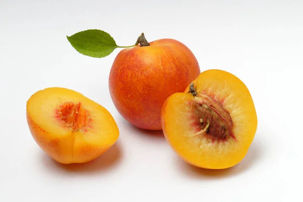 成熟的花蜜或杏与绿叶和切水果与骨头在白色背景 自然的颜色 — 图库照片