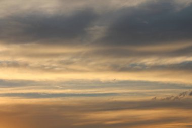 Gün batımında bulutlu bir gökyüzünün boyaları, parlak ve koyu doğal renkler.