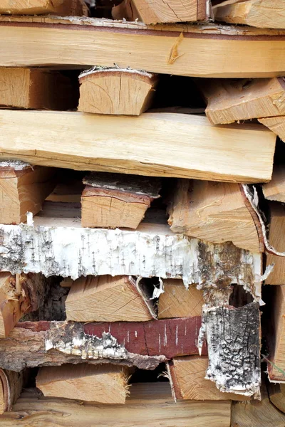 A stack of excellent birch firewood for heating, sauna or bath, natural color, high contrast.