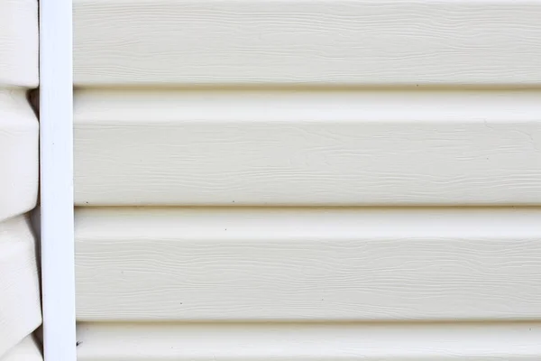 Wall cladding or light-colored siding on the wall with place for text