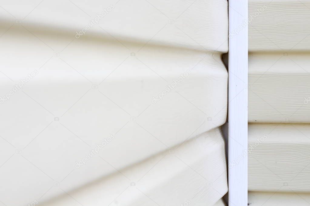 Wall cladding or light-colored siding on the wall with place for text