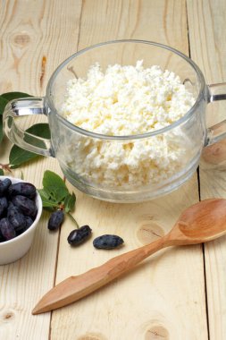 Hanımeli meyveleri ve taze süzme peynir rustik kahvaltı, yakın çekim. Doğal bir ağaçtan arka plan, metnin yeri