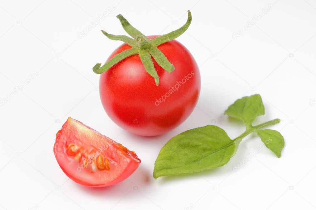 Fresh organic tomato with halves on a white background, bright natural color,