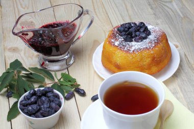 Krema şeker ve taze hanımeli çilek, reçel, bir fincan çay, basit bir rustik kahvaltı ile süzme peynir güveç.