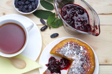 Krema şeker ve taze hanımeli çilek, reçel, bir fincan çay, basit bir rustik kahvaltı ile süzme peynir güveç.