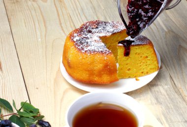 Köy peyniri güveç, taze hanımeli ve reçel, bir fincan çay, basit bir rustik kahvaltı.