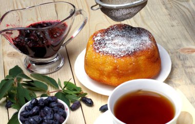 Köy peyniri güveç, taze hanımeli ve reçel, bir fincan çay, basit bir rustik kahvaltı.