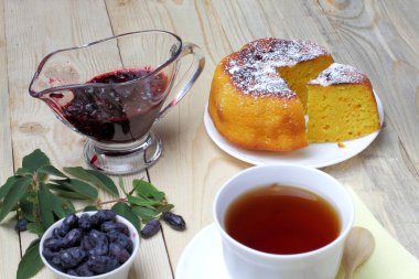 Köy peyniri güveç, taze hanımeli ve reçel, bir fincan çay, basit bir rustik kahvaltı.