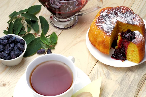 Köy peyniri güveç, taze hanımeli ve reçel, bir fincan çay, basit bir rustik kahvaltı.