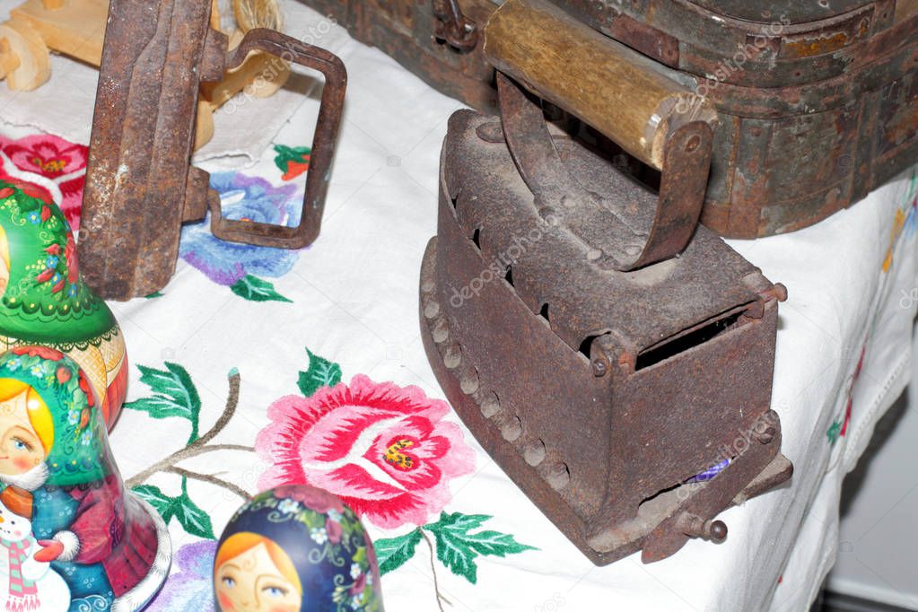 Antique cast iron on the table, surrounded by other vintage household items.