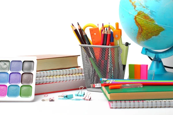 Globe, pencils, watercolor paints and textbooks on a white background, close-up.  Back to school or  education concept. Place for text, copy space.