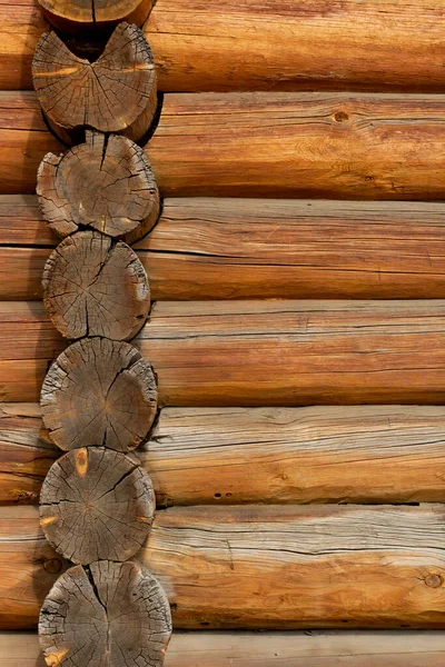Logs of the wall of an ancient building as a texture or backdrop, vertical frame