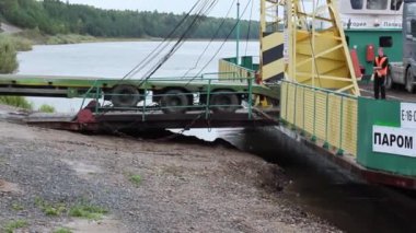 Eniseisk, Rusya, 09 / 03 / 2020 Illustrative Editorial. Arabalar ve kamyonlar feribotu Yenisei Nehri kıyısına bırakır..