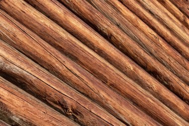 Eski bir ahşap evin yüksek duvarı, yuvarlak kütükler.