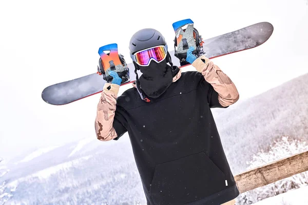 Snowboarder Άνθρωπος Στέκεται Στην Χιονισμένη Πλαγιά Κρατώντας Snowboard Πίσω Από — Φωτογραφία Αρχείου