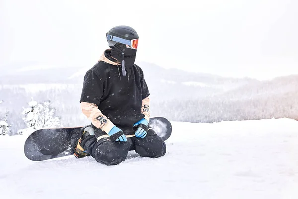 Aufnahme Eines Snowboarders Der Mit Seinem Snowboard Auf Beinen Sitzt — Stockfoto