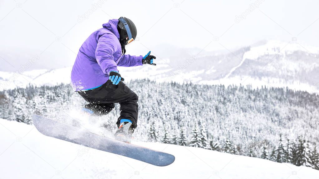 Shot of the freeride snowboarder that is making some trick while riding down from the hill. Extreme winter sport                                 
