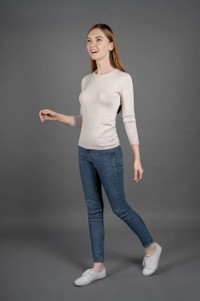 Vertical Shot Cheerful Young Woman Sweater Jeans Walking Look Away — Stock Photo, Image