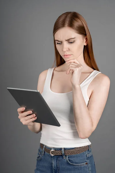 Tiro Vertical Menina Pensativa Que Olhando Para Tablet Lendo Informações — Fotografia de Stock