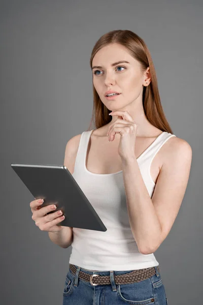 Tiro Vertical Mulher Pensando Com Tablet Sua Mão Olhar Para — Fotografia de Stock