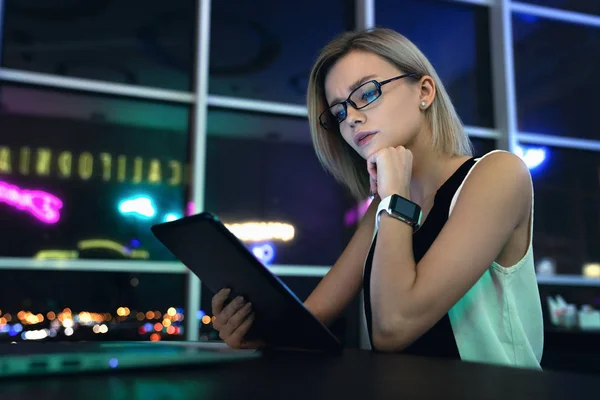 Çalışma sürecinin çekimi. Tam konsantrasyon ile genç kadın yönetici ofis alanında bir masada oturan onu tablet kontrol — Stok fotoğraf