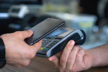 Müşteri kredi kartı kullanarak kablosuz veya temassız ödeme yapıyor. Kasiyer nfc teknolojisi üzerinden ödeme kabul.