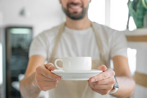 Close-up van Barista met een koffiekop. Koffieshop eigenaar serveren koffie. — Stockfoto