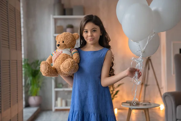 Feliz linda niña con osito de peluche y globos de aire en su mano —  Fotos de Stock
