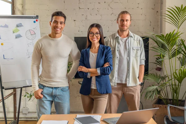 Portrait of successful business team standing together looking at camera and smiling. Positive business people in board room — Stock Photo, Image