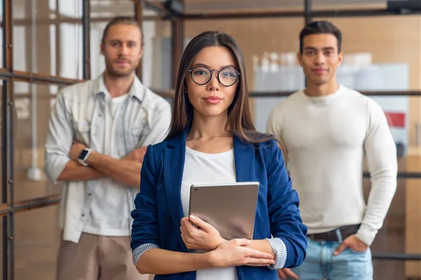 Grupo de jóvenes profesionales corporativos de pie juntos y mirando a la cámara. Gente de negocios multirraciales en el cargo — Foto de Stock