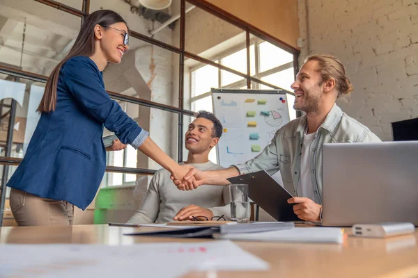 Business people finishing up a meeting. Man shaking hands with female client after successful deal. — Stock Photo, Image