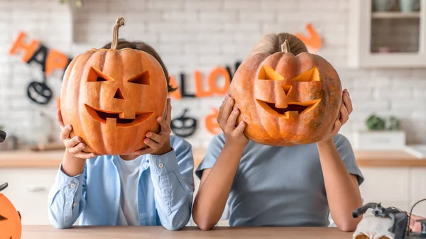 Two little kids celebrating Halloween at home kitchen — 图库照片