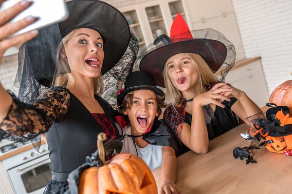 Close up de feliz jovem mulher tomando selfie e se divertindo com seus filhos na cozinha decorada Halloween — Fotografia de Stock