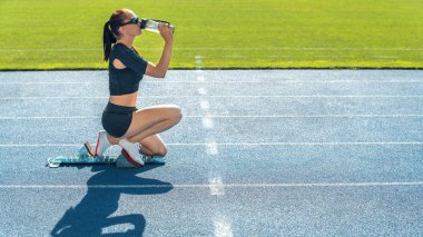 Spor elbiseli genç bir kadının içme suyu içerkenki görüntüsü
