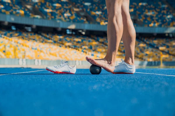 Recortado tiro de mujer atleta haciendo ejercicio para la pierna en una carrera — Foto de Stock