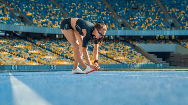 Sportswoman stretching before run on stadium — Stock Photo, Image