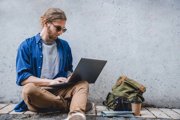Jovem homem astuto trabalhar em laptop ao ar livre. O conceito de estudo, freelancer, trabalho e viagens — Fotografia de Stock