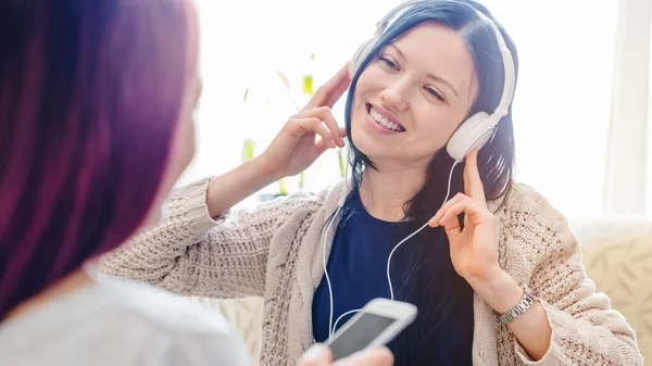 Girls Mendengarkan Musik Smartphone Dengan Earphone Duduk Sofa Rumah — Stok Foto
