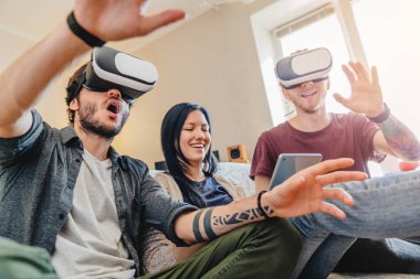 Kanepede otururken VR google 'la eğlenen şaşkın arkadaşların düşük görüşü