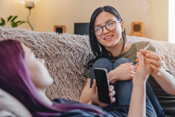 Giovani Amiche Sorridenti Fumano Erba Comune Casa Mentre Rilassano Sul — Foto Stock