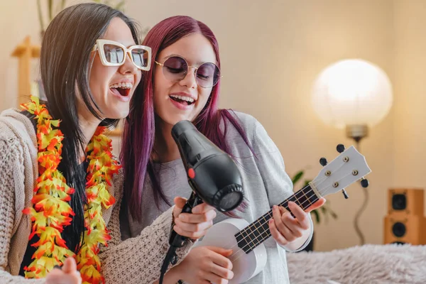 Güneş Gözlüklü Genç Kızlar Evde Saç Kurutma Makinesi Ukulele Ile — Stok fotoğraf