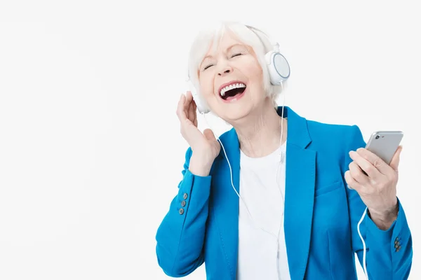 Wanita Senior Dengan Headphone Mendengarkan Musik Telepon Dan Bernyanyi Terisolasi — Stok Foto