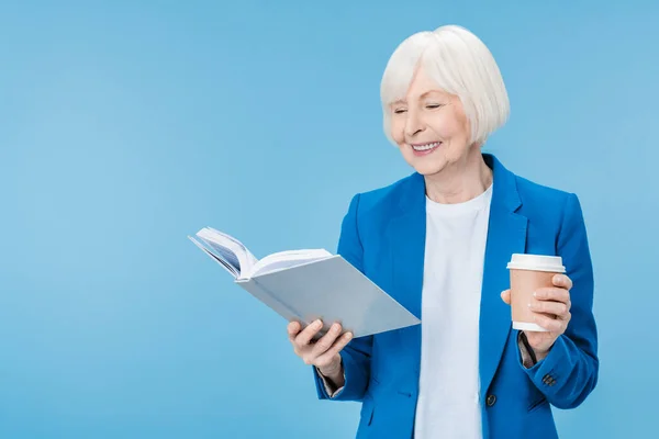 Mulher Madura Leitura Livro Com Xícara Bebida Sobre Fundo Azul — Fotografia de Stock